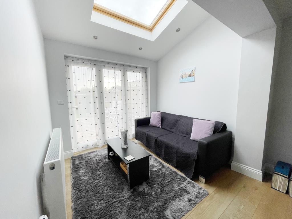 Lot: 57 - THREE-BEDROOM TERRACE HOUSE FOR REPAIR IN POPULAR ESSEX VILLAGE - Sitting room/sunroom with doors to rear garden